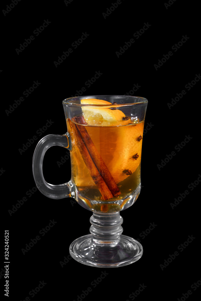 Monochrome transparent cocktail, orange mulled wine in a high glass with a handle with spices and a slice of lemon, orange, side view, iIsolated black background. Drink for the menu restaurant, bar Monochrome transparent cocktail, orange mulled wine in a high glass with a handle with spices and a slice of lemon, orange, side view, iIsolated black background. Drink for the menu restaurant, bar