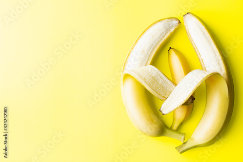 Conceptual image of two big banana parents holding a small baby banana photo