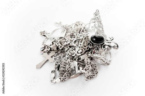 A pile of silver precious jewelry with and without stones. Isolated on white photo