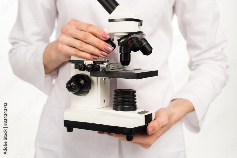cropped view of scientist in white coat holding microscope isolated on white cropped view of scientist in white coat holding microscope isolated on white