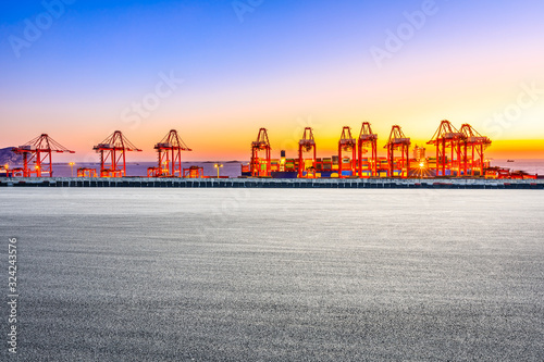 Empty race track and industrial container terminal at beautiful sunset in Shanghai.