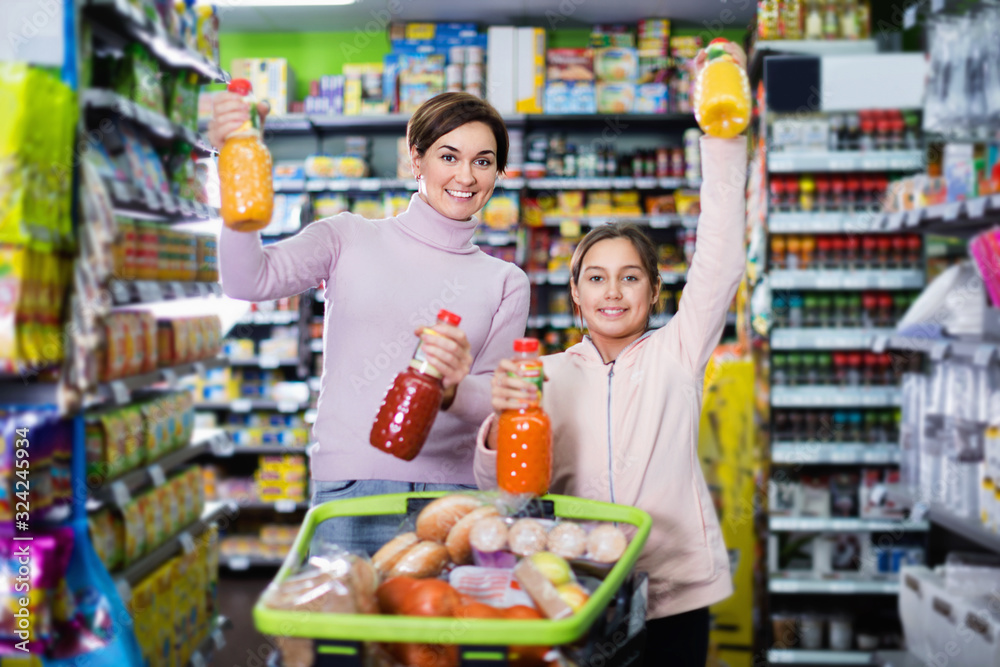 Female shopper with teenage daughter searching for beverages
