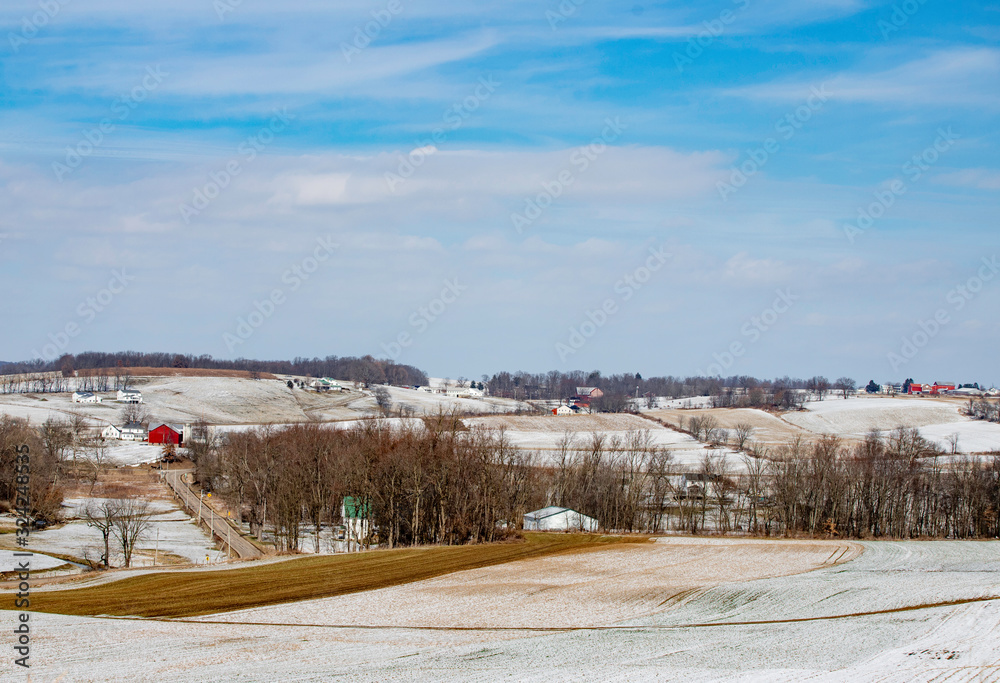 Rural winter scene with red barn and farming
