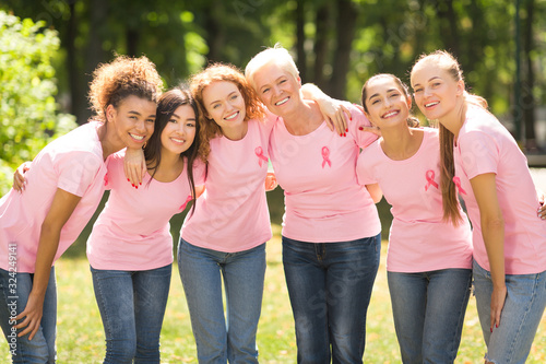 Mutiracial Ladies In Pink T-Shirts With Ribbons Hugging Standing Outdoor