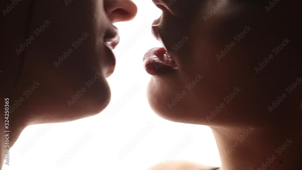 Passionate kiss of lesbian girls close-up. White isolated studio background. LGBT relationships.