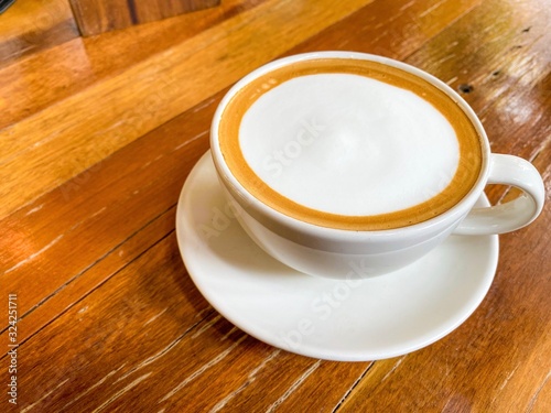 The cup of hot latte coffee or coffee espresso on wood table