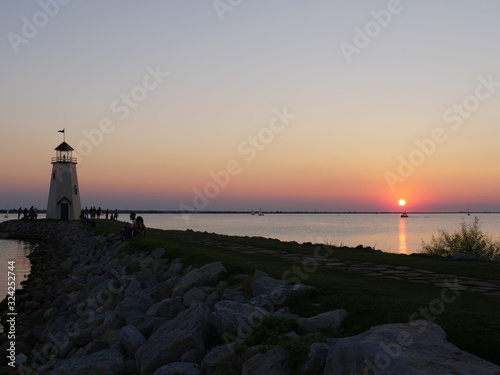 Silhouette of a lighthouse with a beautiful sunset in the distance