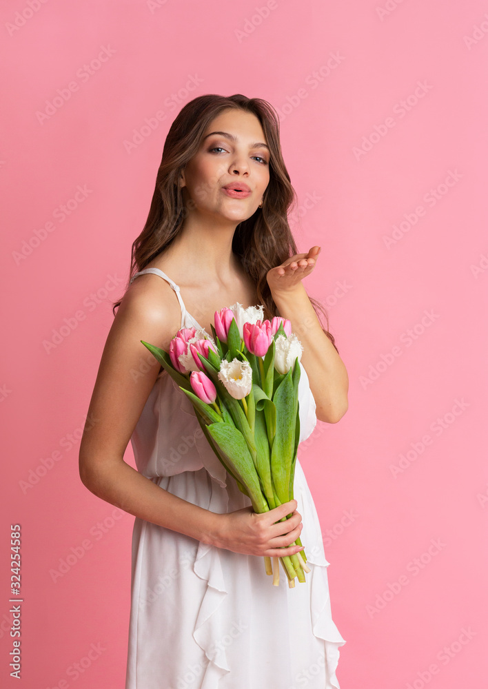 Attractive Young Girl Holding Bouquet Of Tulips And Sending Air Kiss