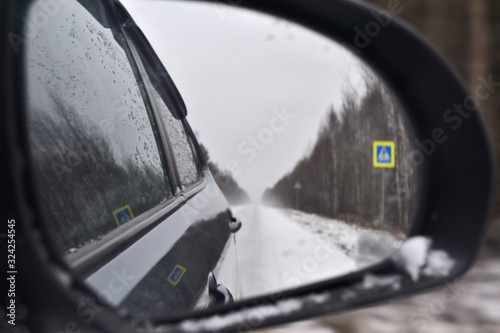 winter road is reflected in the car mirror