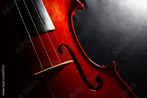 Detalle de violín con enfoque selectivo y fondo degradado en clave baja. photo