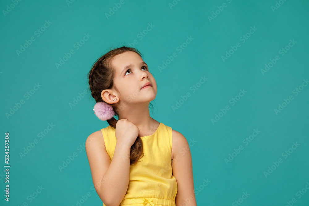 Cute proud little child girl on blue background. Human emotions and facial expression. copy space Cute proud little child girl on blue background. Human emotions and facial expression. copy space