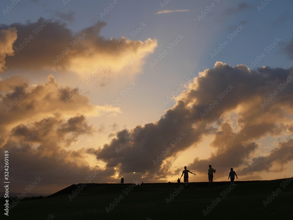 Beautiful clouds in the skies with the silhouette of people at sunset in Puerto Rico.