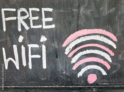 View text of free WIFI sign handwriting on black chalkboard. Sign free WIFI area sign at a coffee shop.