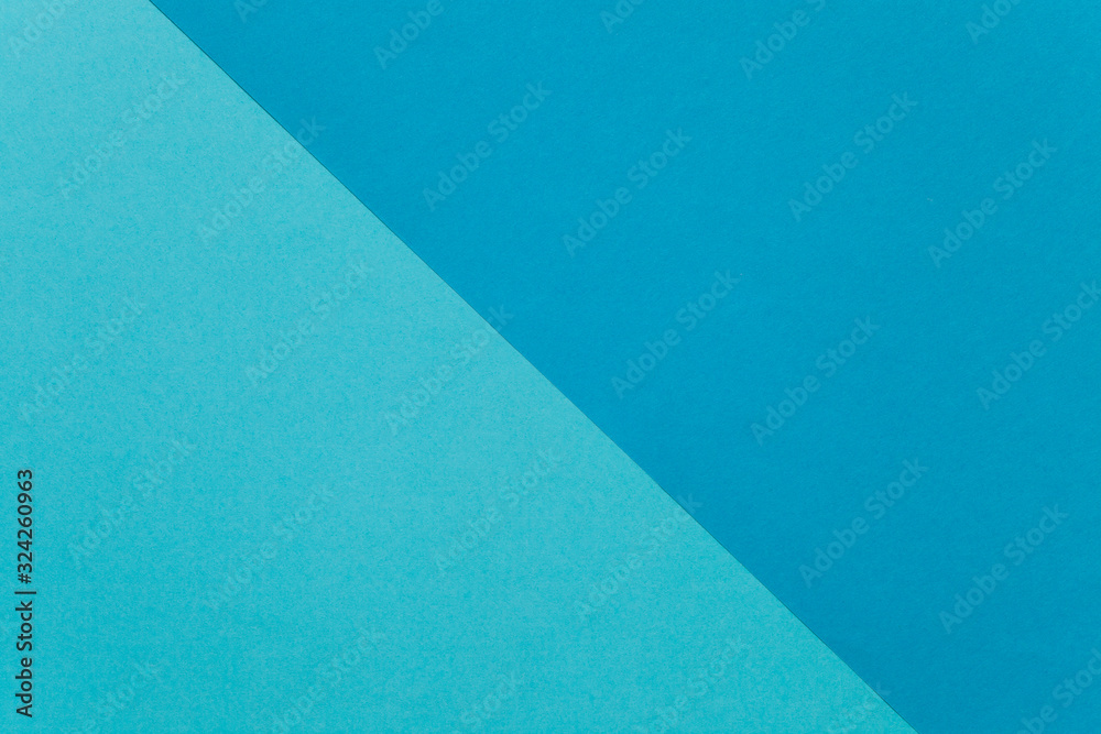 Two sheets of colored paper on the diagonal, light blue and dark blue. Minimalism background.