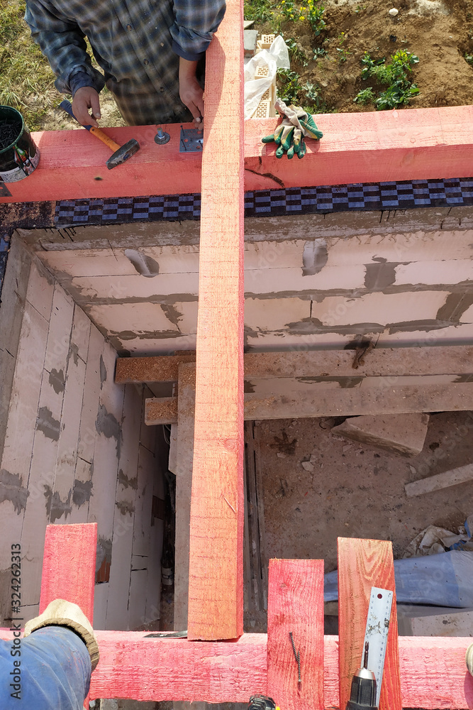 Installation of wooden beams in the construction of the roof system of