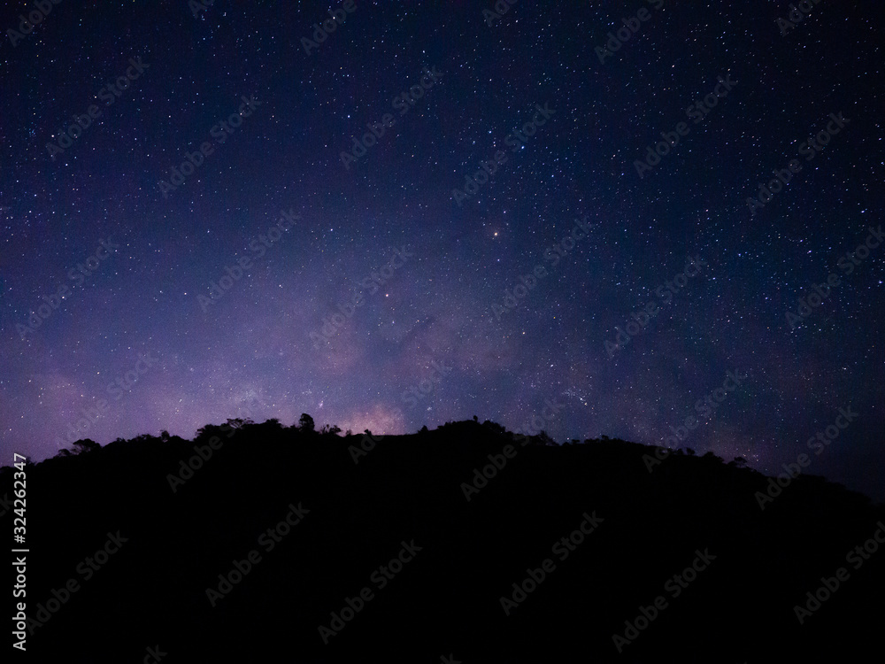 beautiful night sky from milky way galaxy with stars and meteor over mountain at national park, Thailand on February 2020