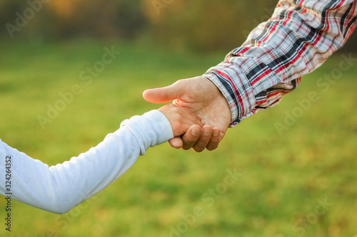 a beautiful hands of parent and child outdoors in the park