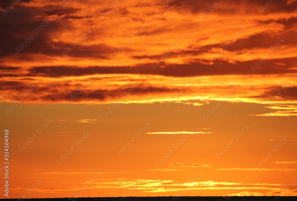 Medium close up of skies on fire at sunset