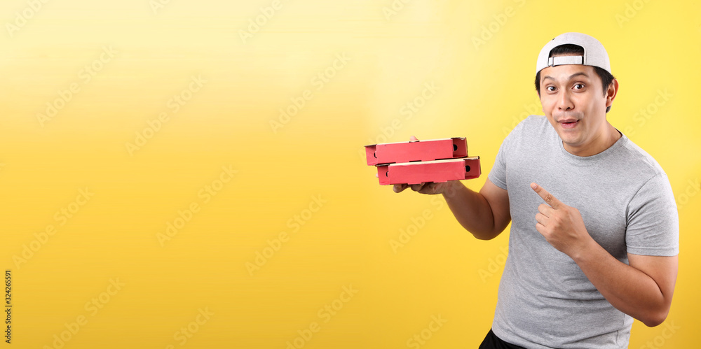 Pizza delivery happy smile Asian man,isolated on yellow background in studio With copy space. Pizza delivery happy smile Asian man,isolated on yellow background in studio With copy space.