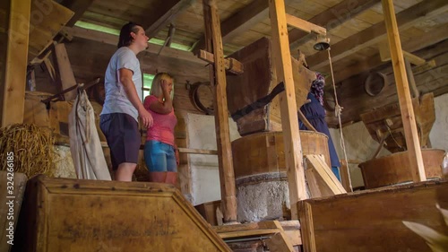 Miller explain to tourist couple how cereal is grinded photo