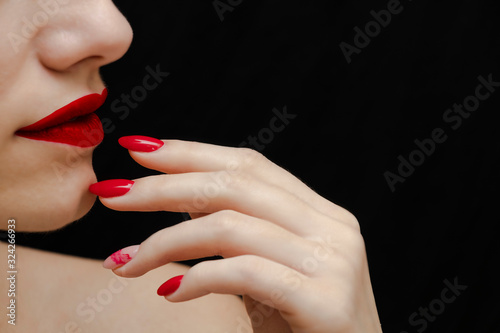 Face, red lips, red manicure. Black background. Beautiful face. Beauty around. Fashion and Style. Be yourself.