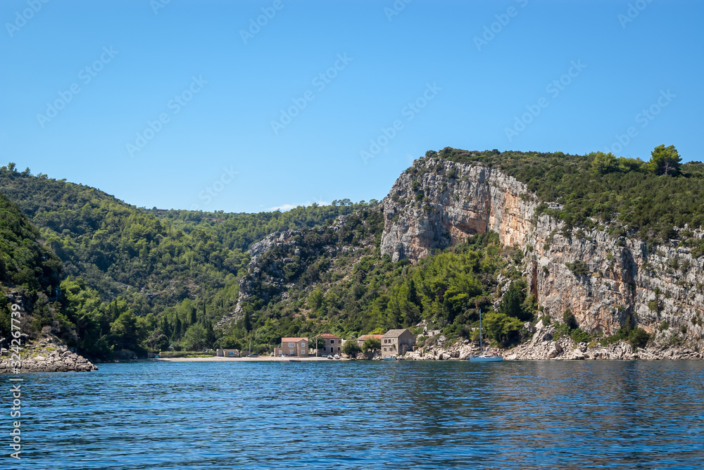 Beautiful small bay with several traditional stone houses, turquoise blue waters and a moored yacht, Pokrivenik bay, Island of Hvar, Croatia. Beautiful small bay with several traditional stone houses, turquoise blue waters and a moored yacht, Pokrivenik bay, Island of Hvar, Croatia.