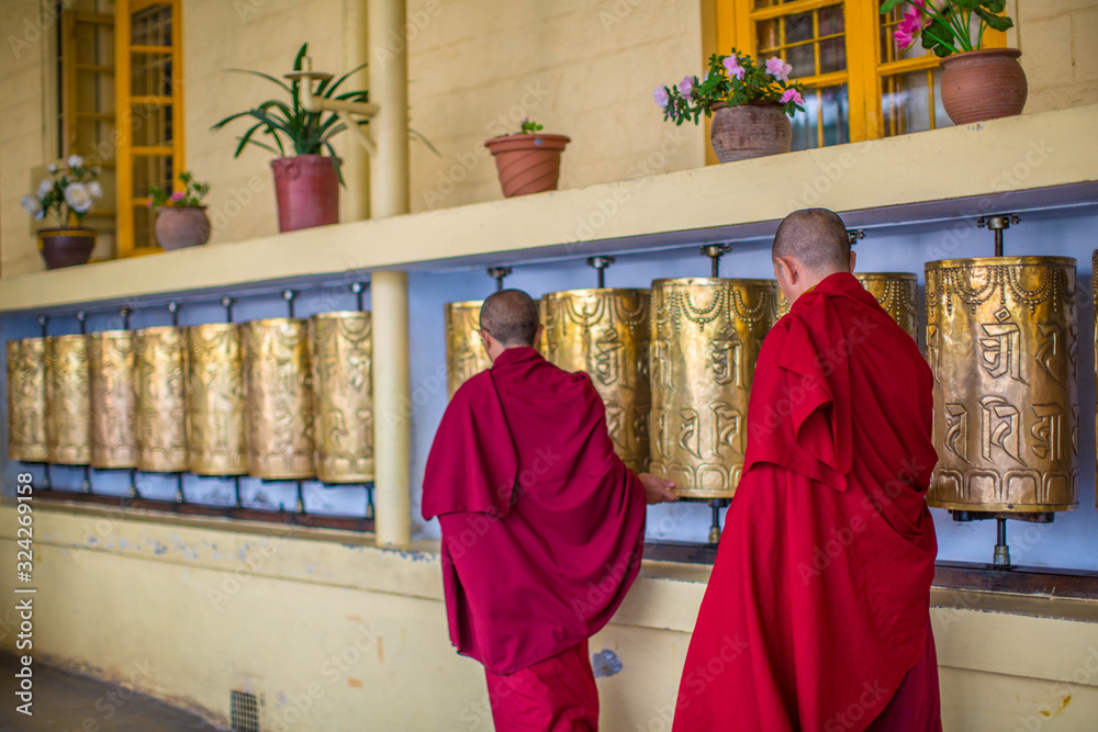 Monks spin the golden wheels. Buddhist prayer wheel Dharamshala India