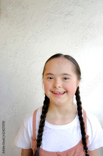 Portrait of little girl smiling on background of the wall
