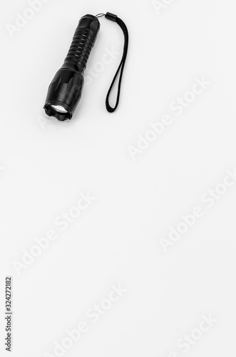 black aluminium body flashlight on a white surface