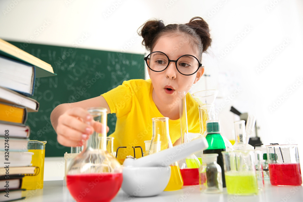 Schoolchild making experiment at table in chemistry class Schoolchild making experiment at table in chemistry class