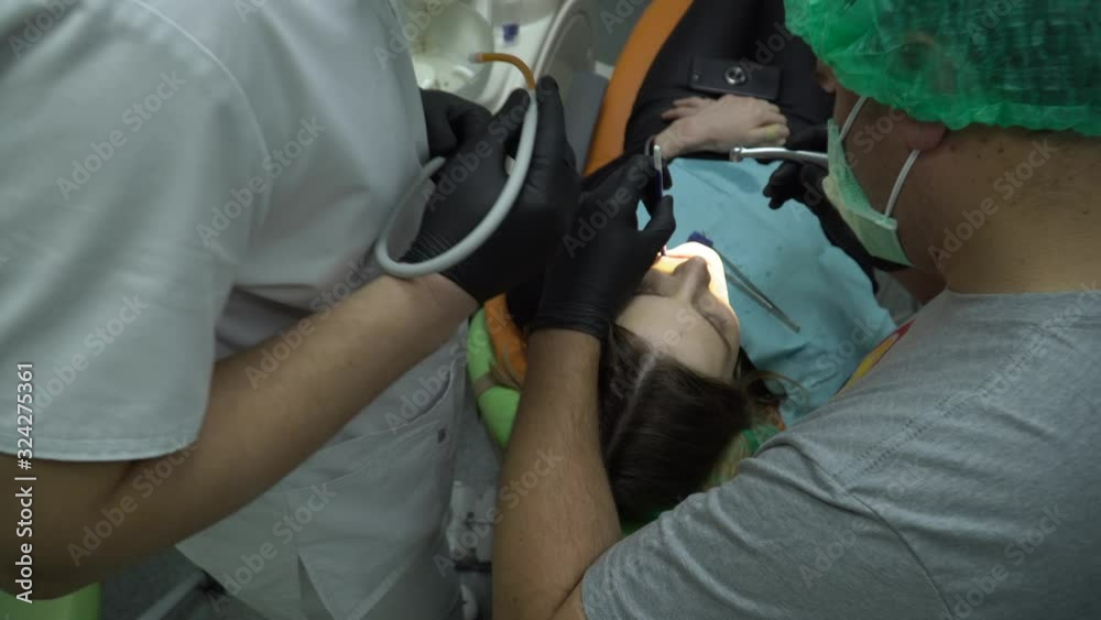 Dolly shot. Dentist doctors working with woman patient at dental clinic. Dolly shot. Dentist doctors working with woman patient at dental clinic.
