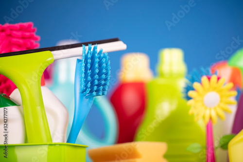 Spring house cleaning. Colorful cleaning kit on blue background.