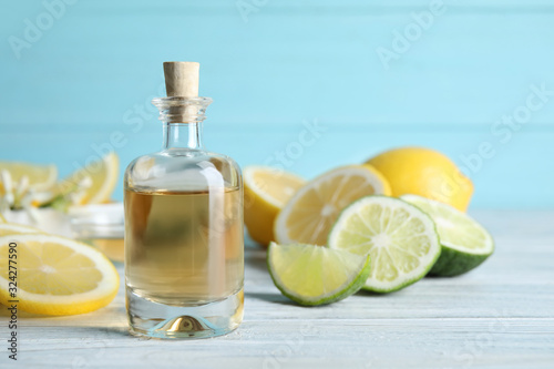 Citrus essential oil on white wooden table. Space for text