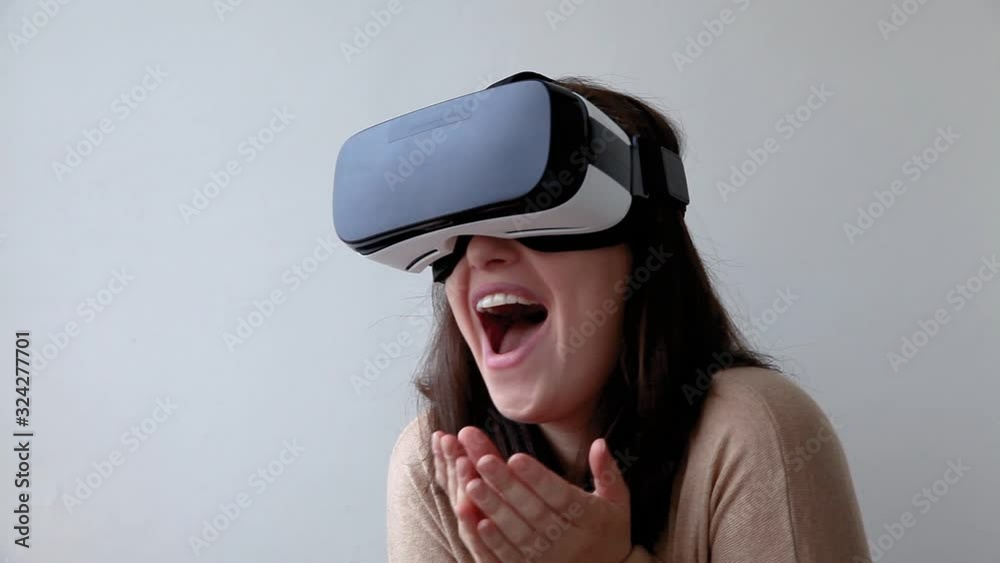 Smile young woman wearing using virtual reality VR glasses helmet headset on white background. Smartphone using with virtual reality goggles. Technology, simulation, hi-tech, videogame concept Smile young woman wearing using virtual reality VR glasses helmet headset on white background. Smartphone using with virtual reality goggles. Technology, simulation, hi-tech, videogame concept