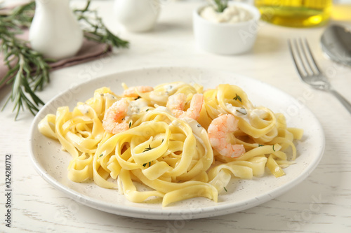 Delicious pasta with shrimps on white wooden table