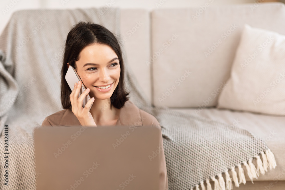 Woman talking on cellphone sitting on the floor Woman talking on cellphone sitting on the floor