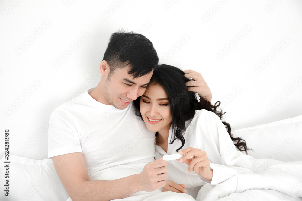 young couple having test pregnant in bed young couple having test pregnant in bed
