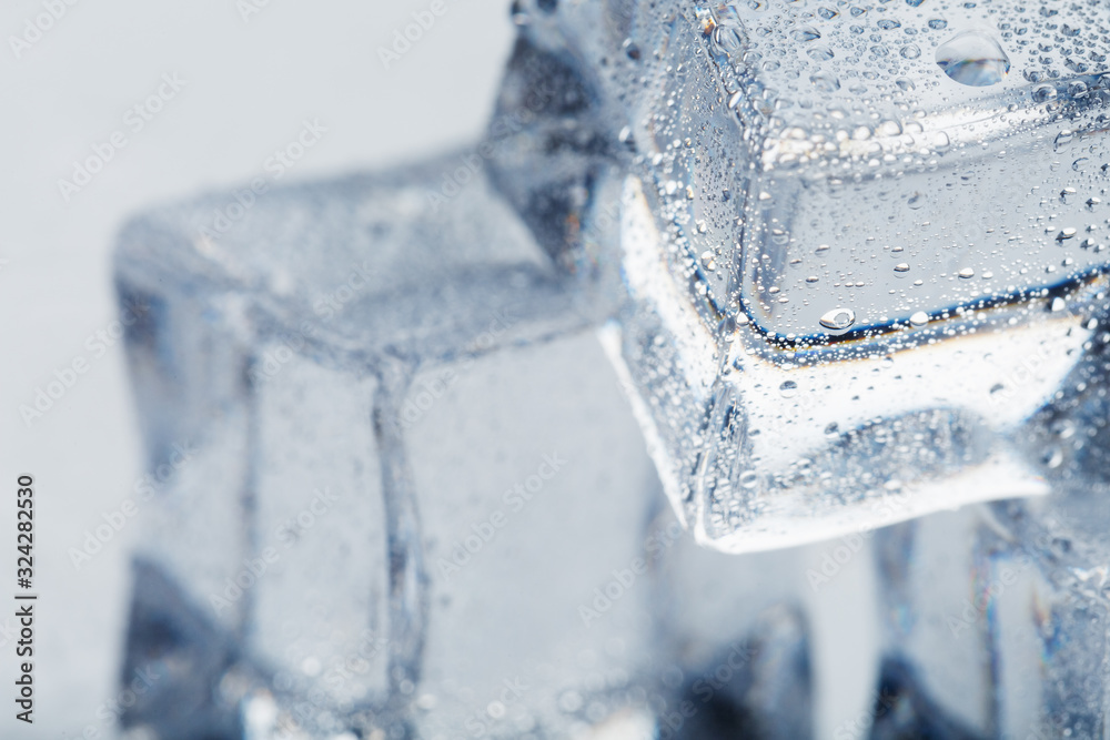 Ice cube with water drops close - up in macro on a white background. Refreshing ice. Isolate Ice cube with water drops close - up in macro on a white background. Refreshing ice. Isolate