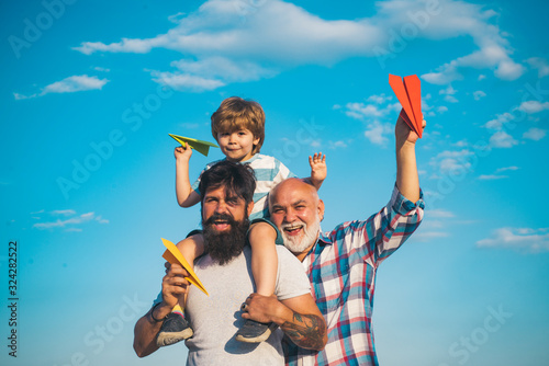 Fathers day - grandfather, father and son are hugging and having fun together. © Volodymyr