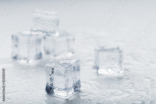 Ice cubes in the form of a pyramid with water drops close - up in macro on a white background.