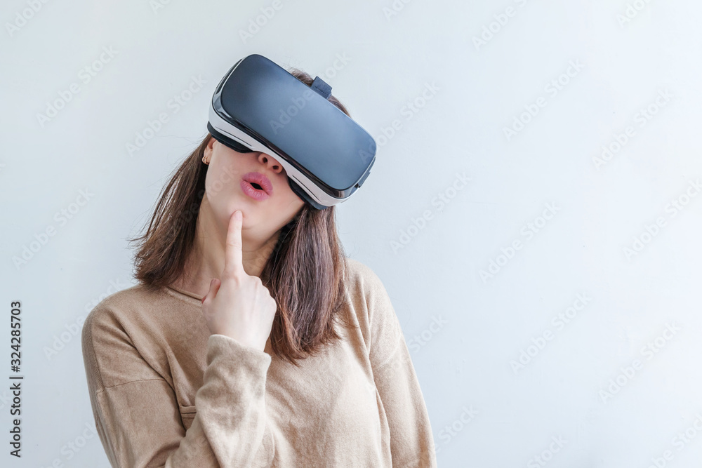 Smile young woman wearing using virtual reality VR glasses helmet headset on white background. Smartphone using with virtual reality goggles. Technology, simulation, hi-tech, videogame concept. Smile young woman wearing using virtual reality VR glasses helmet headset on white background. Smartphone using with virtual reality goggles. Technology, simulation, hi-tech, videogame concept.