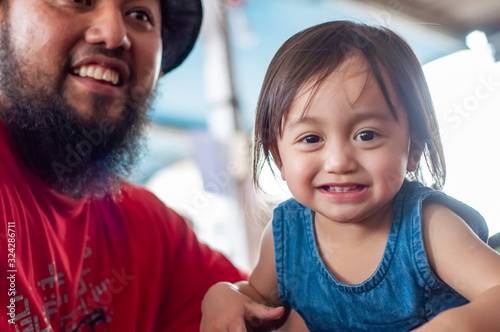 Krabi, Thailand - January 21, 2019: Portrait of malay toddler and bearded father.