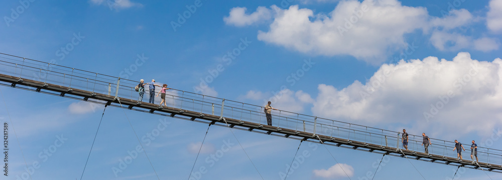 Panorama of tourists crossing the suspension bridge in Geierlay, Germany