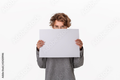 Pretty young woman holding empty blank paper board with copy space for text photo