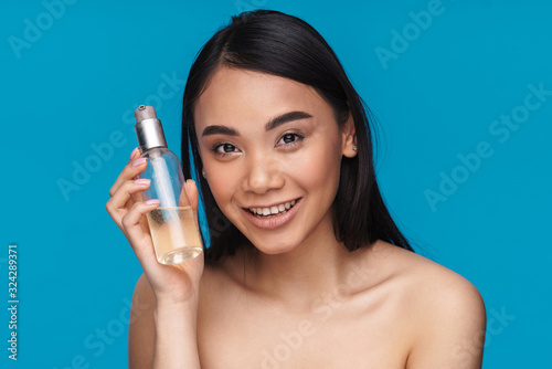 Woman posing isolated holding bottle with cosmetic oil.