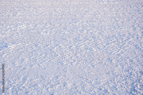 Texture. Fresh snow with traces of car treads.