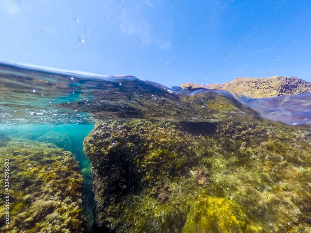 Split underwater view of rocks in Alghero shore.