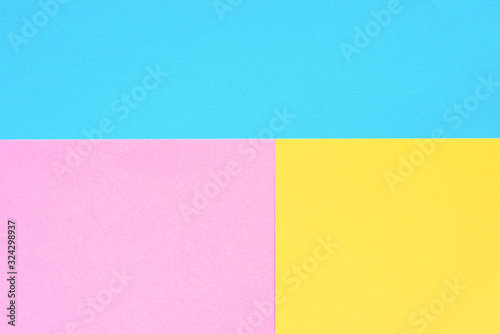 Blue, yellow and pink colored paper. Geometric empty paper background of three tones for copy space.