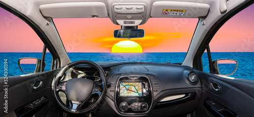 Car windshield view of beautiful sunset by the sea, Italy