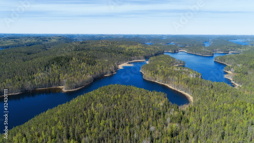 Aerial view of green spring forest and blue lake in Finland. Kolovesi National park.